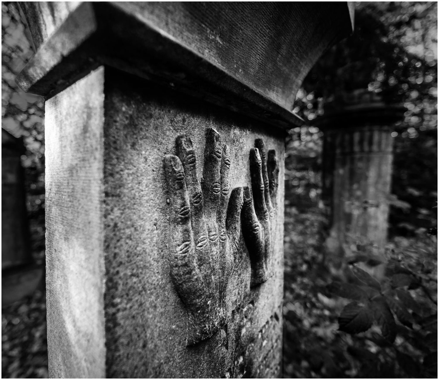 Schwarz-Weiß-Fotografie: Jüdischer Grabstein, in den zwei Hände eingemeißelt sind
