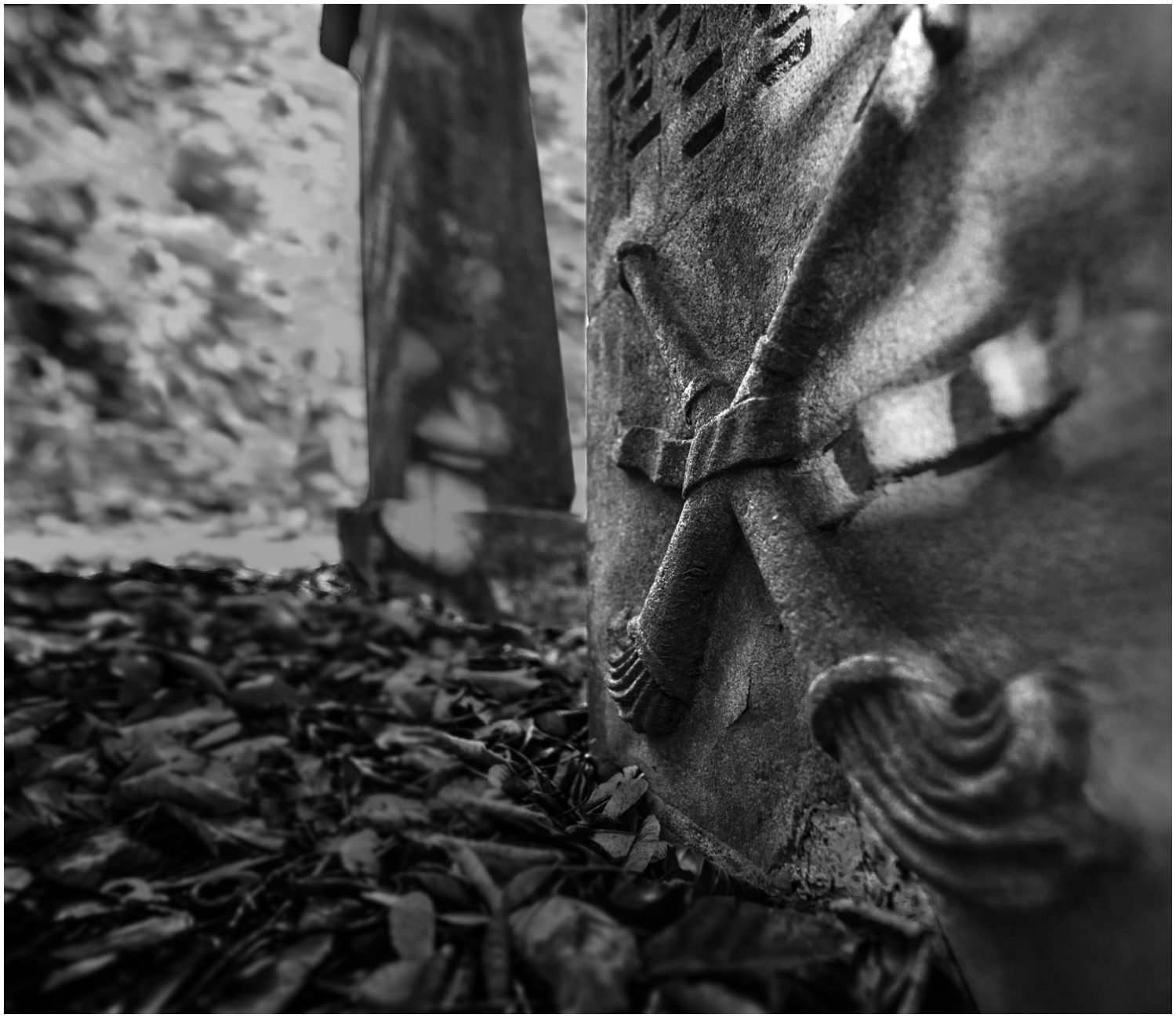 Schwarz-Weiß-Fotografie: Jüdischer Grabstein, in den zwei Tora-Rollen eingemeißelt sind