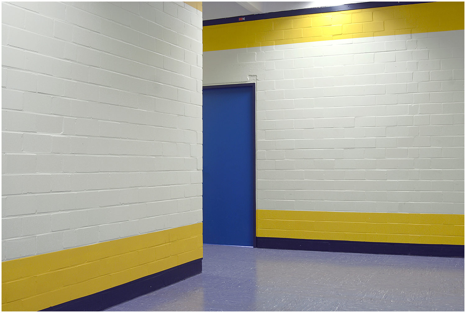 Flur mit blauer Tür und gelb-weiß gestrichen Wänden
