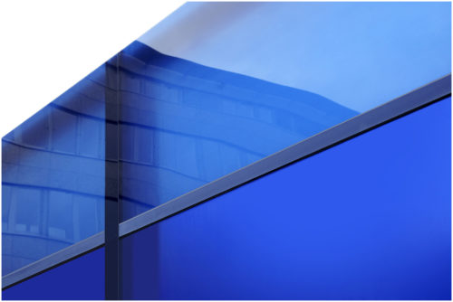 Blaue Glaswand mit Spiegelung einer Hausfassade