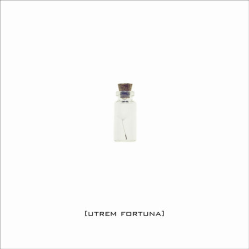 Eine kleine Glasflasche mit einem Loewenzahnsamen in Originalgroesse, beschriftet mit dem lateinischen Begriff ,Utrem Fortuna'.