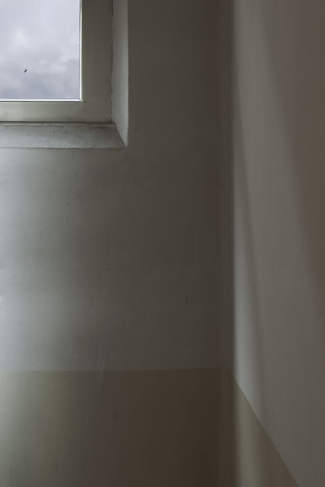 Farbreduzierte Fotografie von einer Zimmerecke mit kleinem Fenster